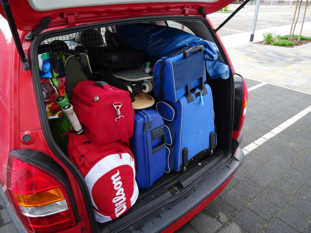 coffre de voiture rouge rempli de bagages et équipements de voyage en famille