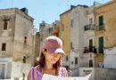 jeune femme avec carte touristique devant bâtiments anciens méditerranéens