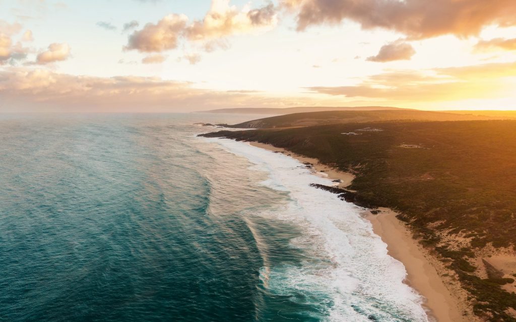 vue aérienne d'une plage de sable blanc et de falaises côtières en australie-occidentale au coucher du soleil