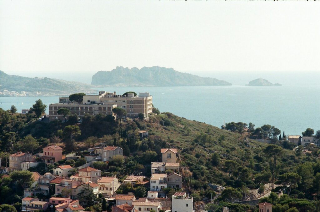 vue côtière méditerranéenne avec village aux toits rouges et îles en arrière-plan