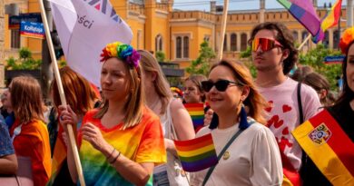 Celebrating diversity and inclusion at Wrocław Pride Parade with colorful flags and joyful participants.
