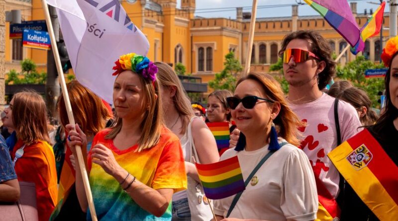 Celebrating diversity and inclusion at Wrocław Pride Parade with colorful flags and joyful participants.