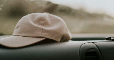 Minimalistic scene of a beige cap on a car dashboard, offering a sense of travel and style.