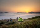 Capture of a serene camping scene at sunrise with a view over a sea of clouds and mountains.
