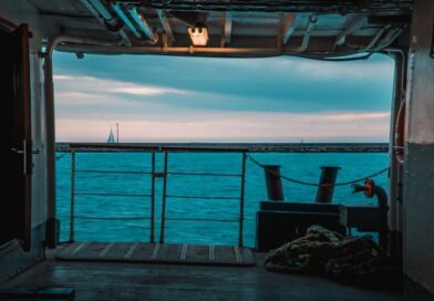 A serene view of the sea from a ferry deck in İstanbul with sailboats on the horizon.
