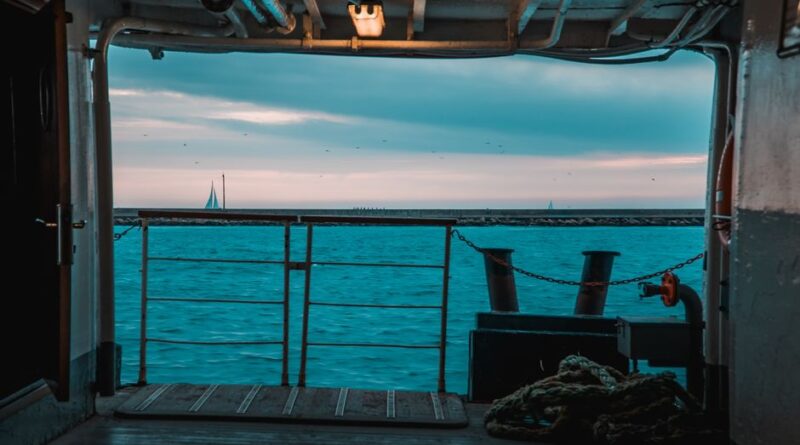 A serene view of the sea from a ferry deck in İstanbul with sailboats on the horizon.