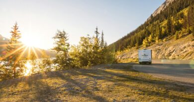 An rv drives along a scenic mountain road at sunset