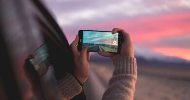 A person captures a stunning Icelandic sunset through a smartphone while traveling.