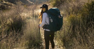 a woman with a backpack walking on a trail