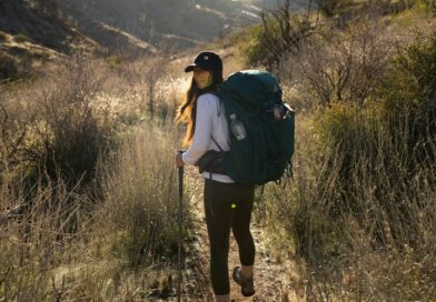 a woman with a backpack walking on a trail