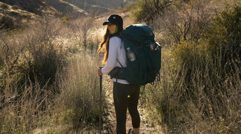 a woman with a backpack walking on a trail