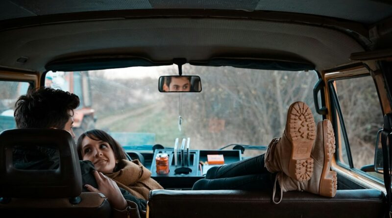 man sitting on bucket seat while woman on his lap